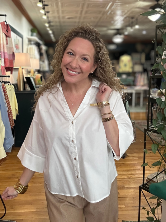 Woman wearing a white blouse and beige pants in a store setting