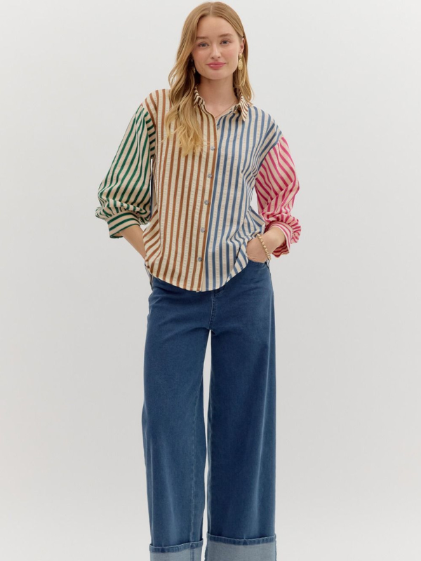 Woman wearing a colorful striped shirt and blue jeans on a white background