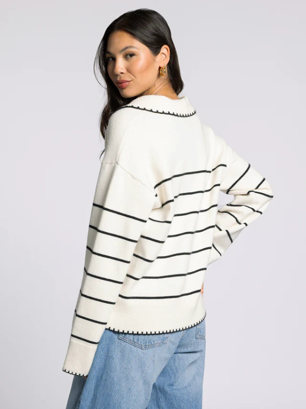 woman wearing cream sweater with black stripes