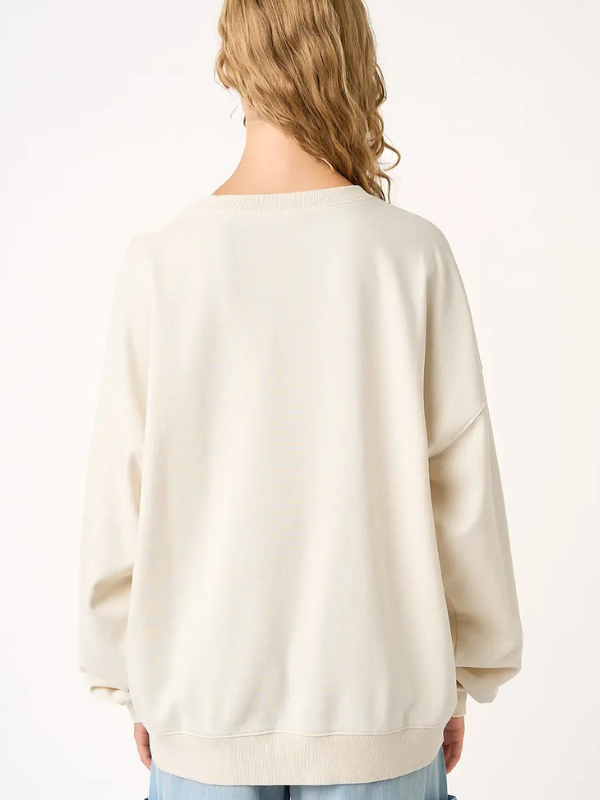 Person wearing a beige sweater on a white background