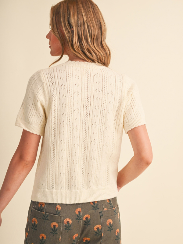 woman wearing a cream pointelle sweater