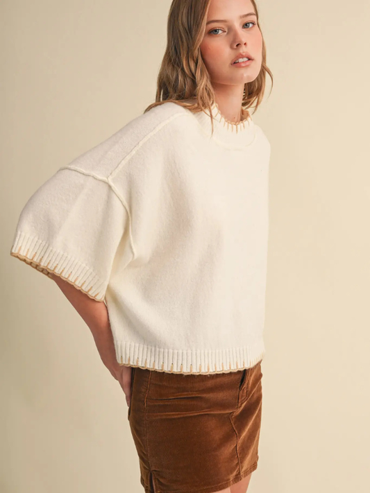 woman wearing a cream blanket stitched sweater