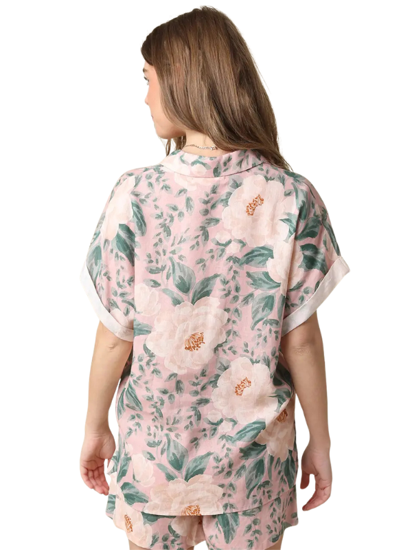 Woman wearing a pink floral kimono-style outfit on a white background