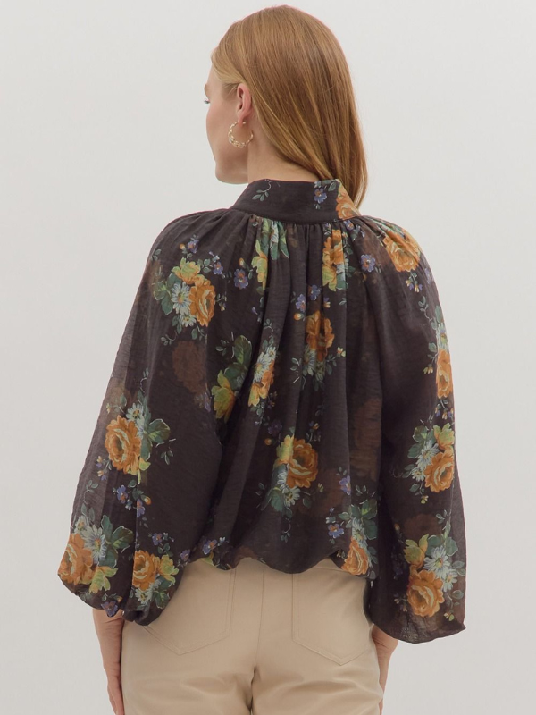 Woman wearing a floral blouse with a plain background