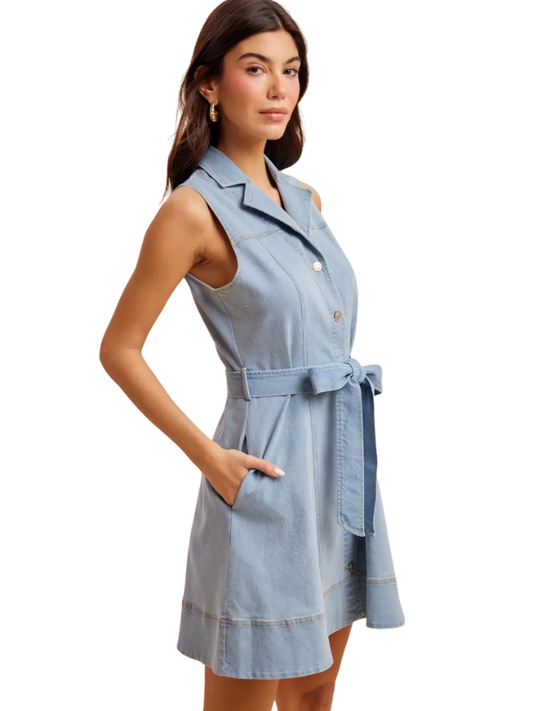 Woman wearing a light blue denim dress on a white background