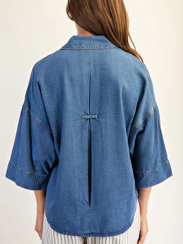Blue denim shirt worn by a person on a white background