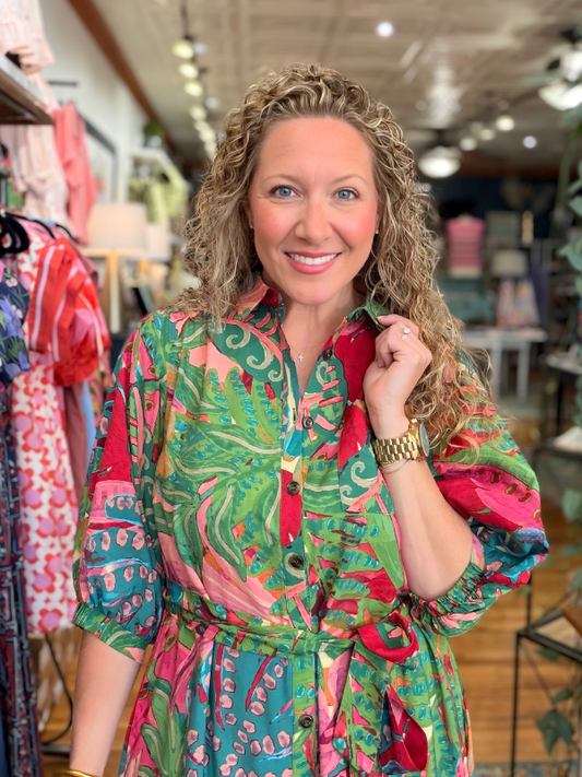 Woman wearing a colorful patterned dress in a store setting