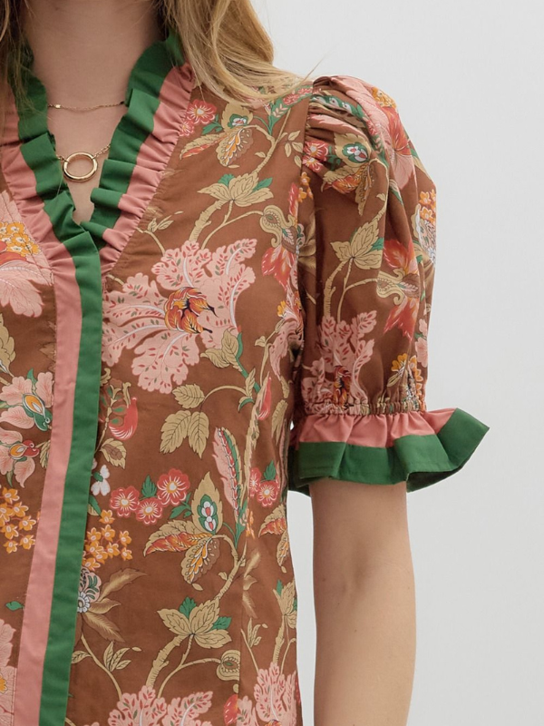 Floral patterned garment with green trim on a plain background