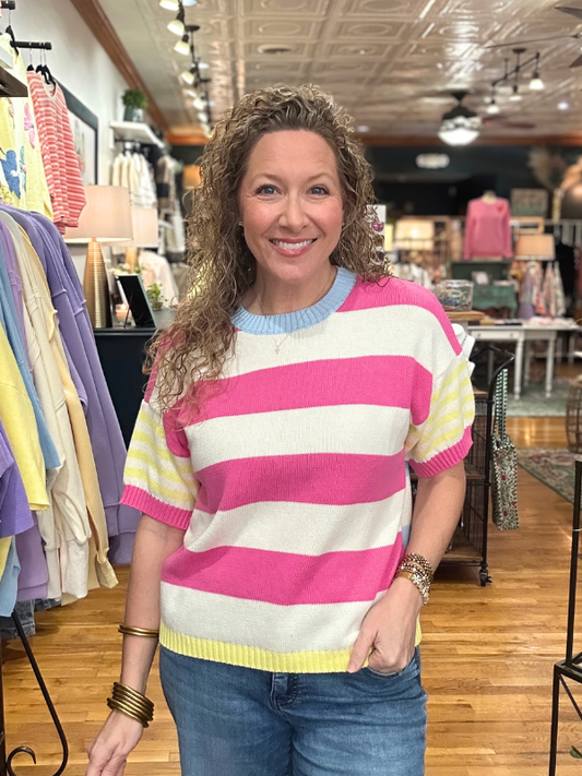 Woman wearing a colorful striped sweater in a clothing store