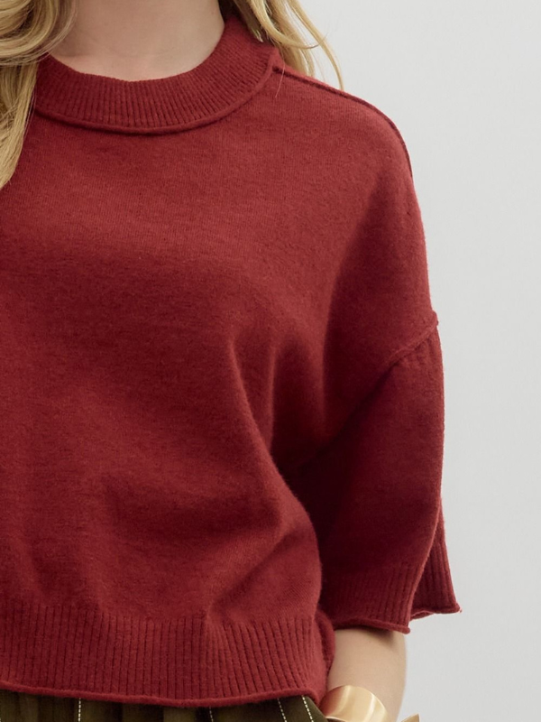 Red sweater worn by a person on a light gray background