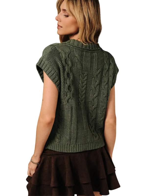 A woman shown from the back wearing a dark olive green cable-knit short-sleeve sweater and a dark brown ruffled skirt, against a plain white background.