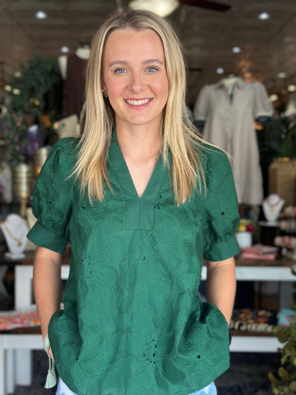 Woman wearing a green blouse in a store setting