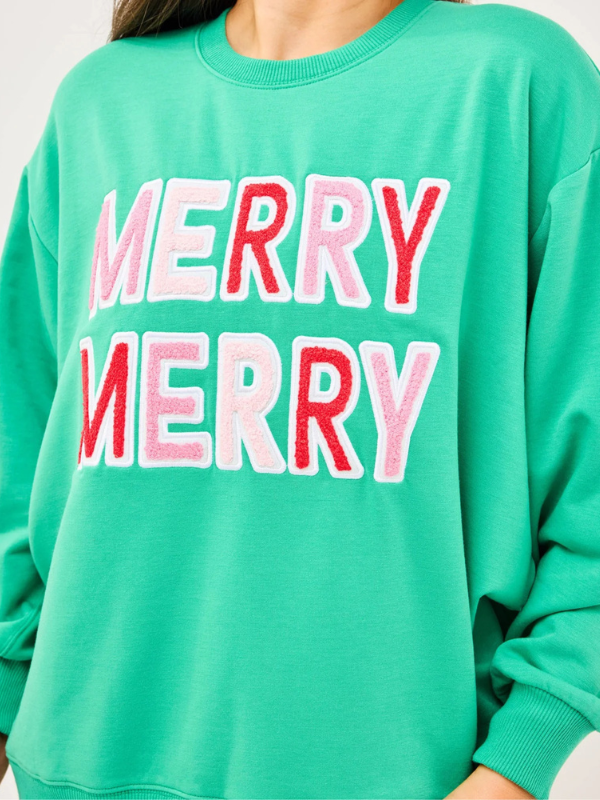 Green sweatshirt with 'MERRY MERRY' text in red and pink on a white background
