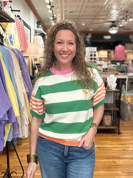 Woman wearing a colorful striped sweater in a clothing store