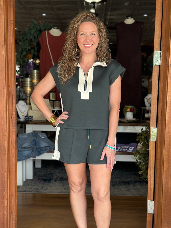 Woman wearing a green outfit with a white collar in a store setting