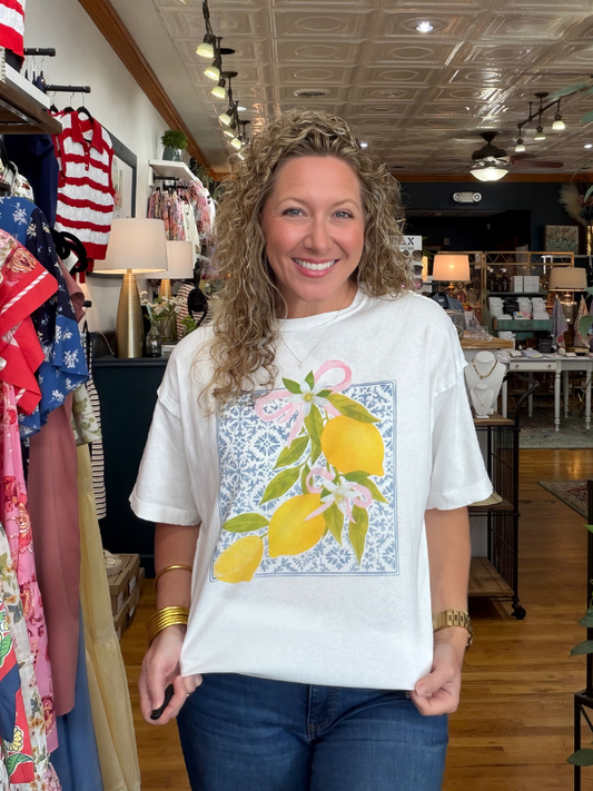 Woman wearing a white t-shirt with a lemon design in a store setting