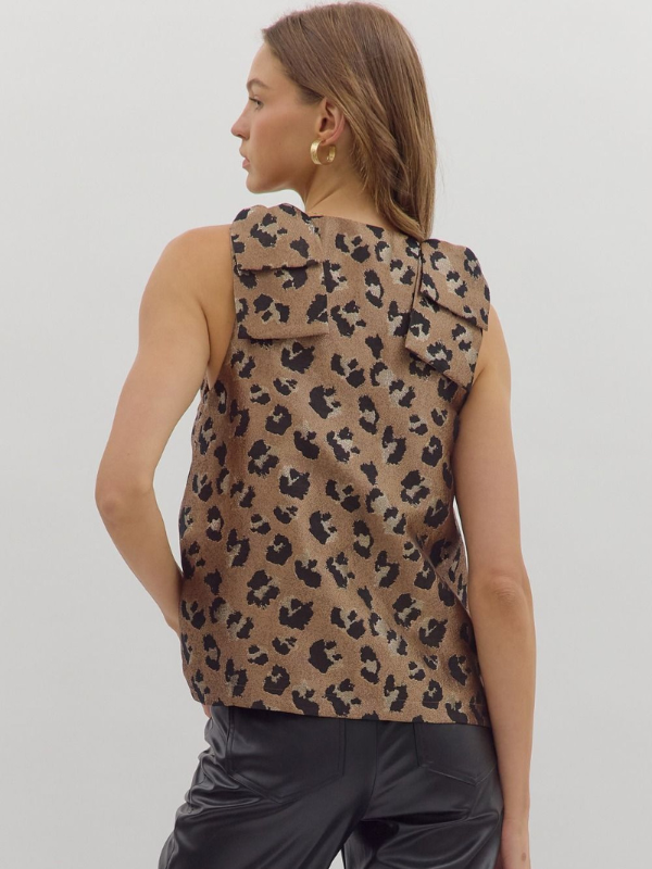 Woman wearing a leopard print sleeveless top against a plain background