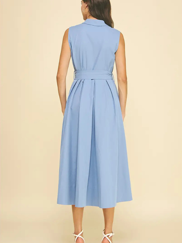 Woman wearing a light blue sleeveless dress on a beige background