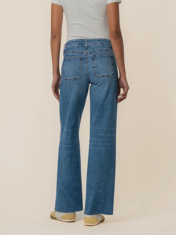 Person wearing blue jeans on a beige background