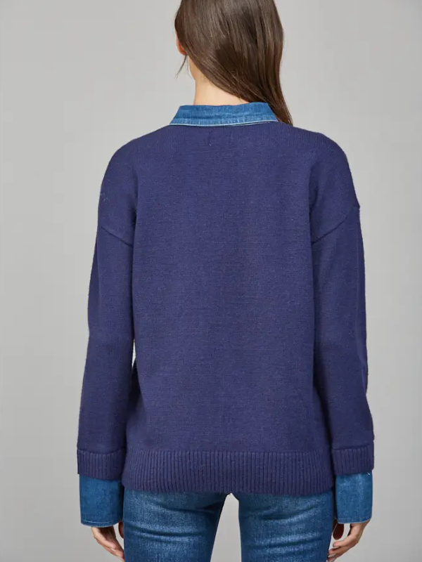 Person wearing a blue sweater with a gray background