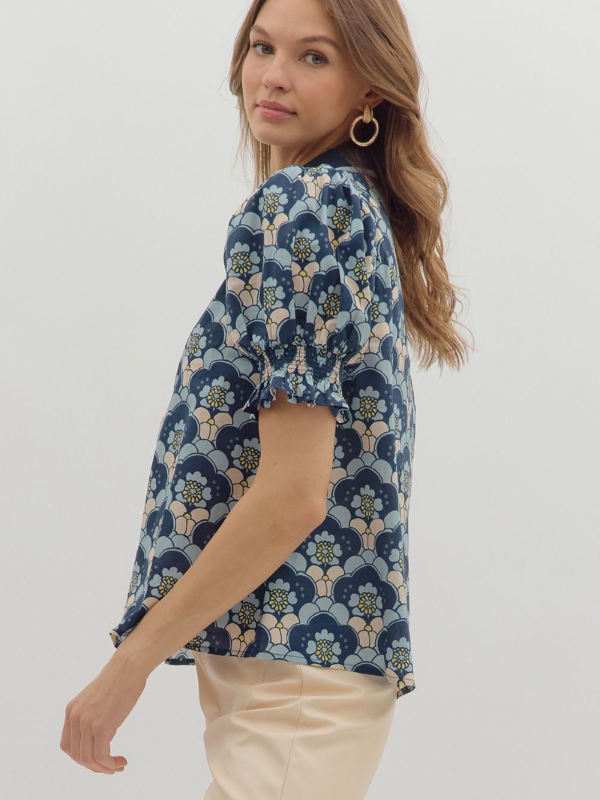 Woman wearing a blue floral blouse against a white background