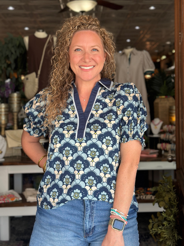Woman wearing a patterned shirt in a store setting