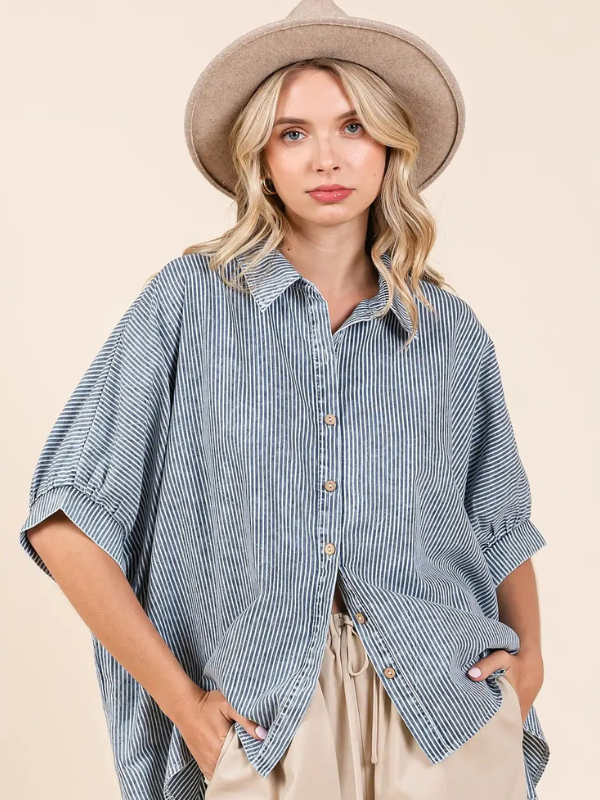 Woman wearing a blue striped shirt and beige hat on a beige background
