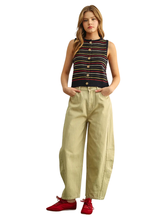 A woman modeling a sleeveless striped knit top with buttons, paired with wide-leg beige pants and red shoes, against a plain white background.