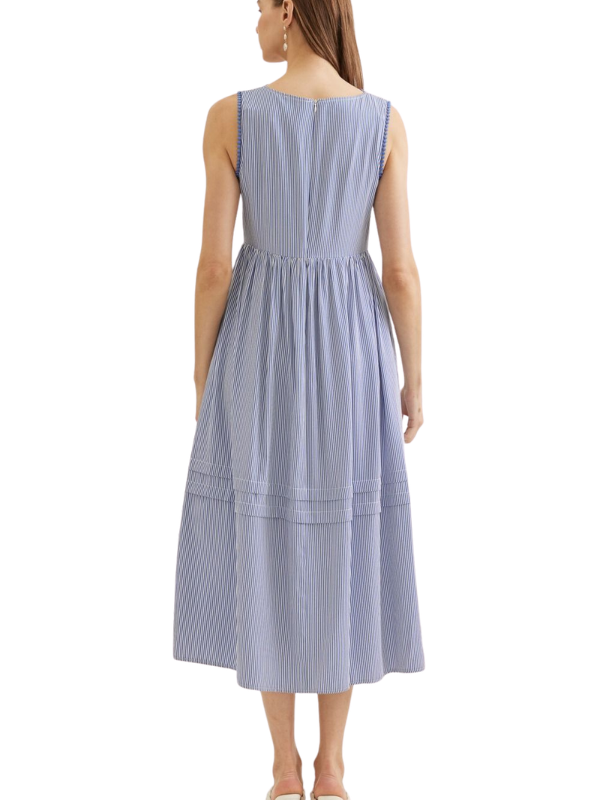 Woman wearing a sleeveless blue and white striped dress on a white background