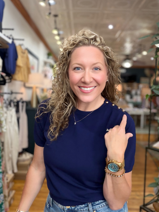 Woman in a store pointing at the camera