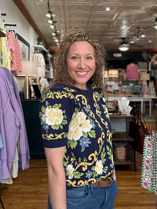 Woman wearing a floral top in a store setting