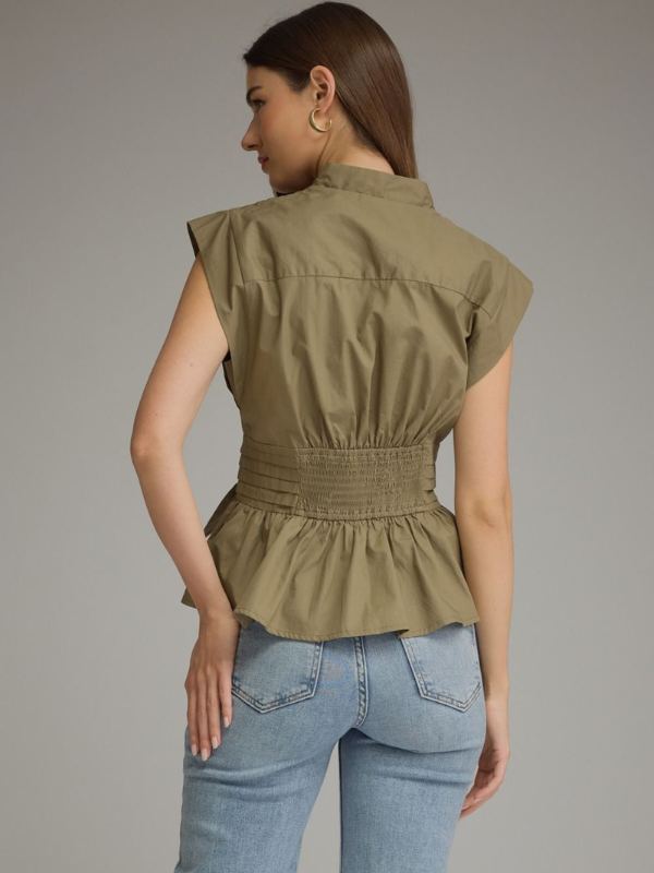 woman wearing an olive sleeveless top and jeans