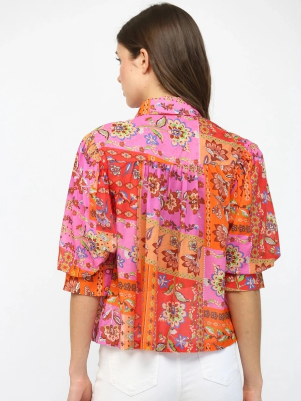 Woman wearing a colorful patterned blouse on a white background