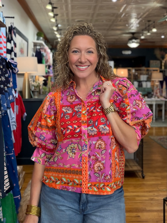 Woman wearing a colorful patterned shirt in a store setting