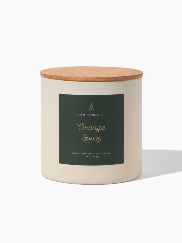 Candle with a wooden lid labeled 'Orange Spice' on a white background