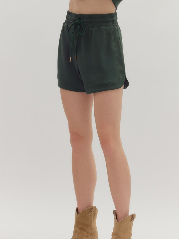Green shorts worn by a person on a plain background