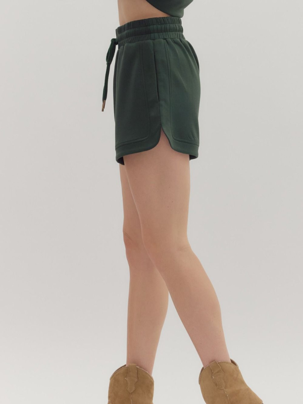 Green shorts worn by a person on a plain background