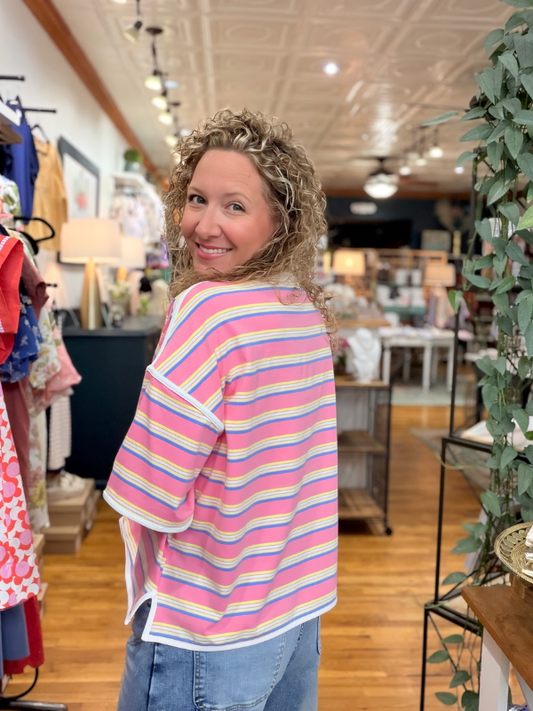 Woman wearing a colorful striped shirt in a store setting