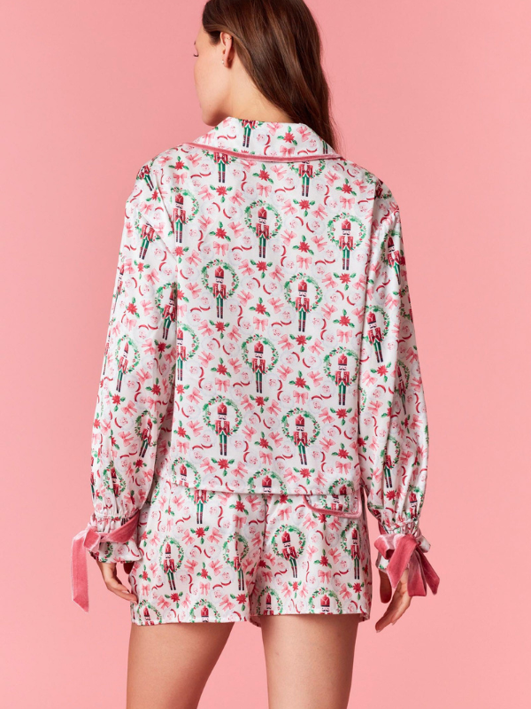 Person wearing a festive pajama set with a pink background