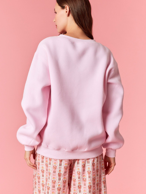Person wearing a pink sweatshirt against a pink background