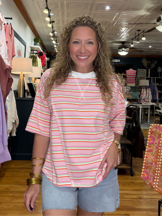 Woman wearing a striped shirt and shorts in a store setting