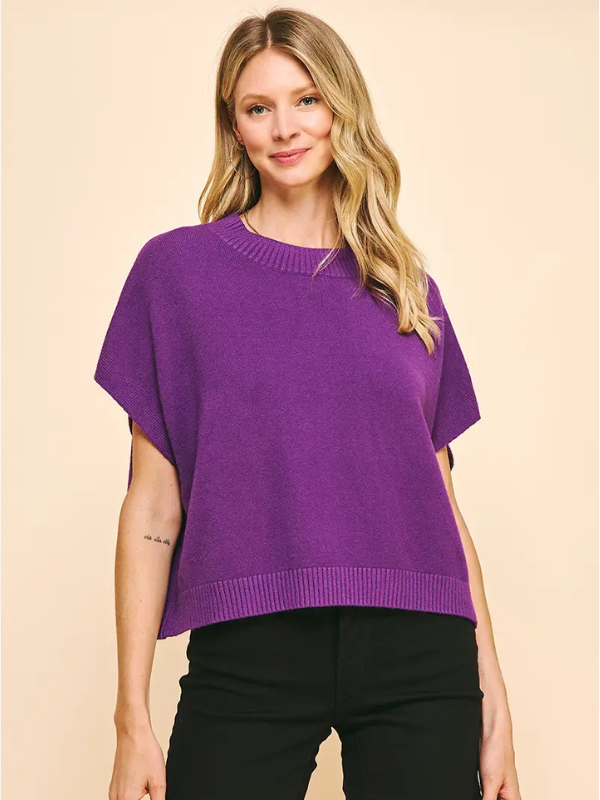 Woman wearing a purple sweater against a beige background