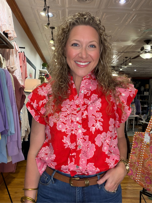 Woman wearing a red floral blouse in a clothing store