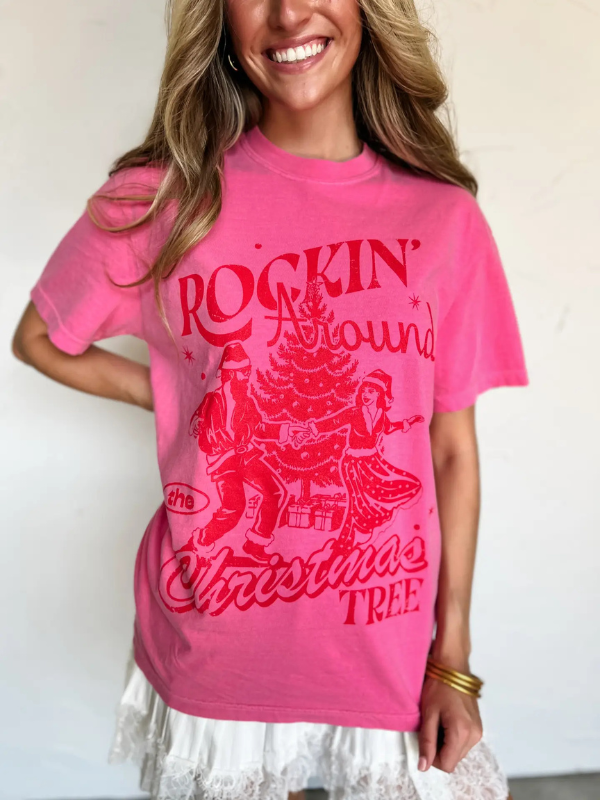 Person wearing a pink t-shirt with red graphic design and text.