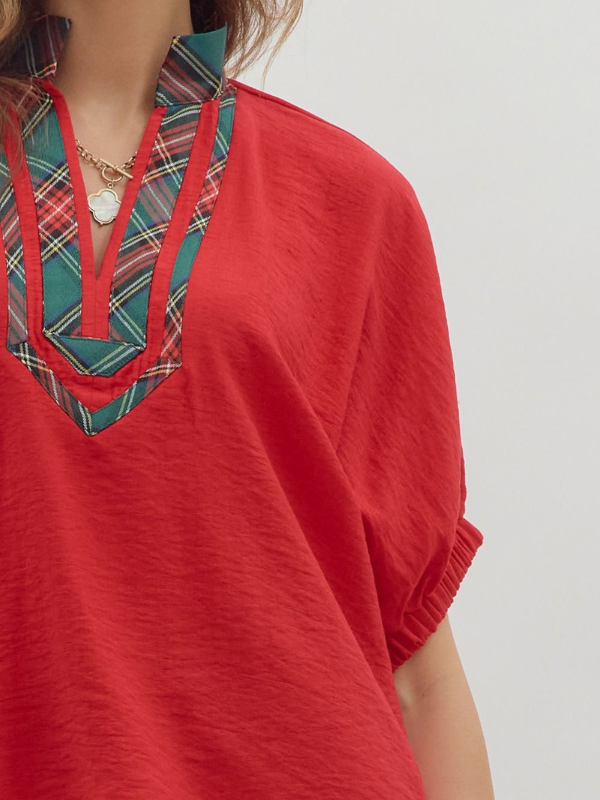 Red top with plaid neckline on a white background