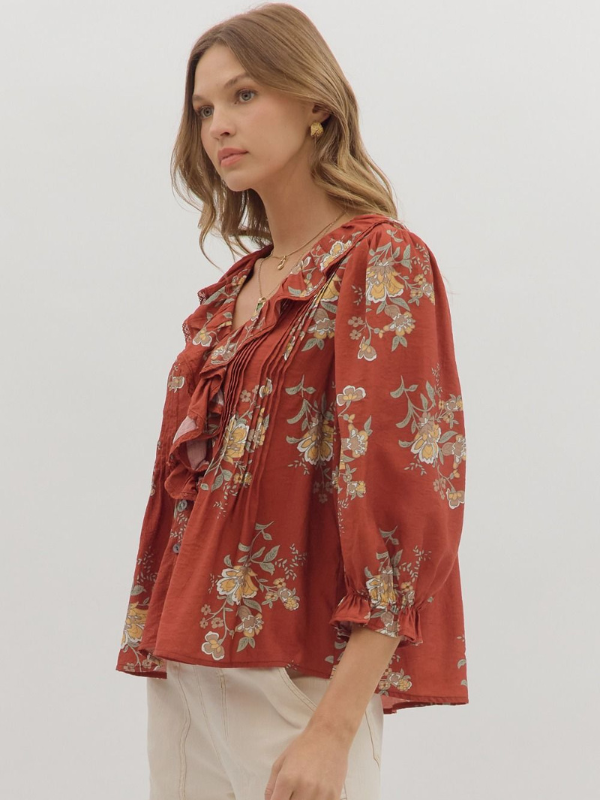 Woman wearing a red floral blouse against a white background