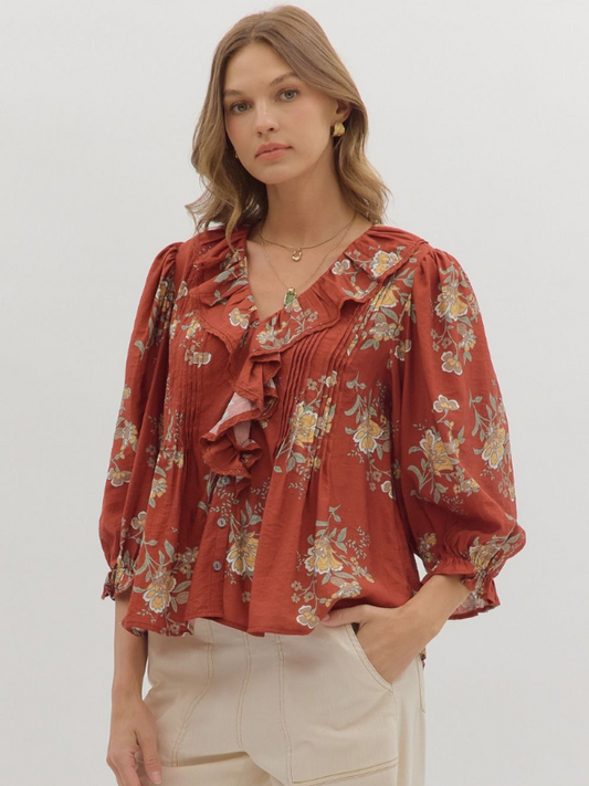 Woman wearing a red floral blouse against a white background