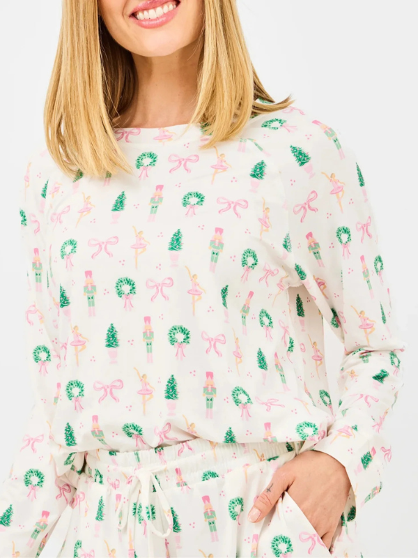 Person wearing a white dress with festive print on a plain background