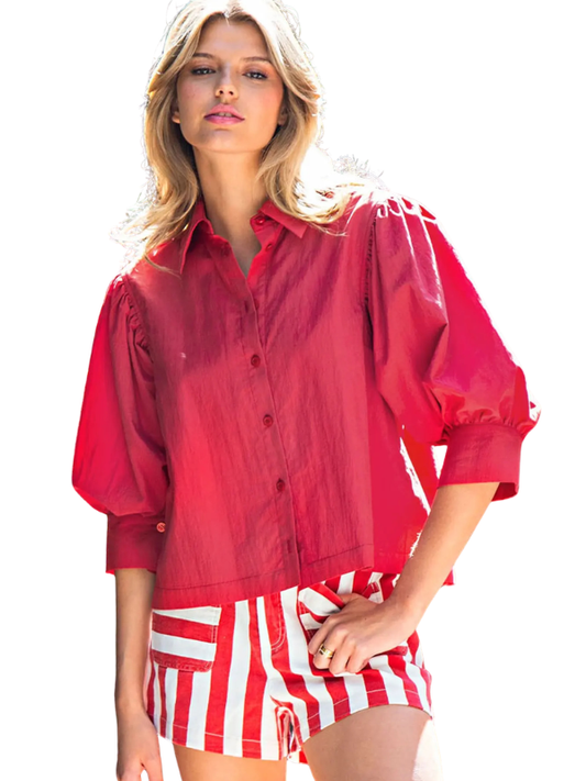 woman wearing a red top and striped shorts