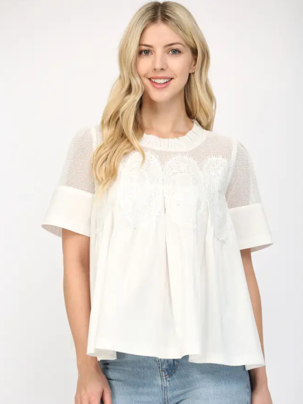 Woman wearing a white blouse with sheer sleeves on a white background
